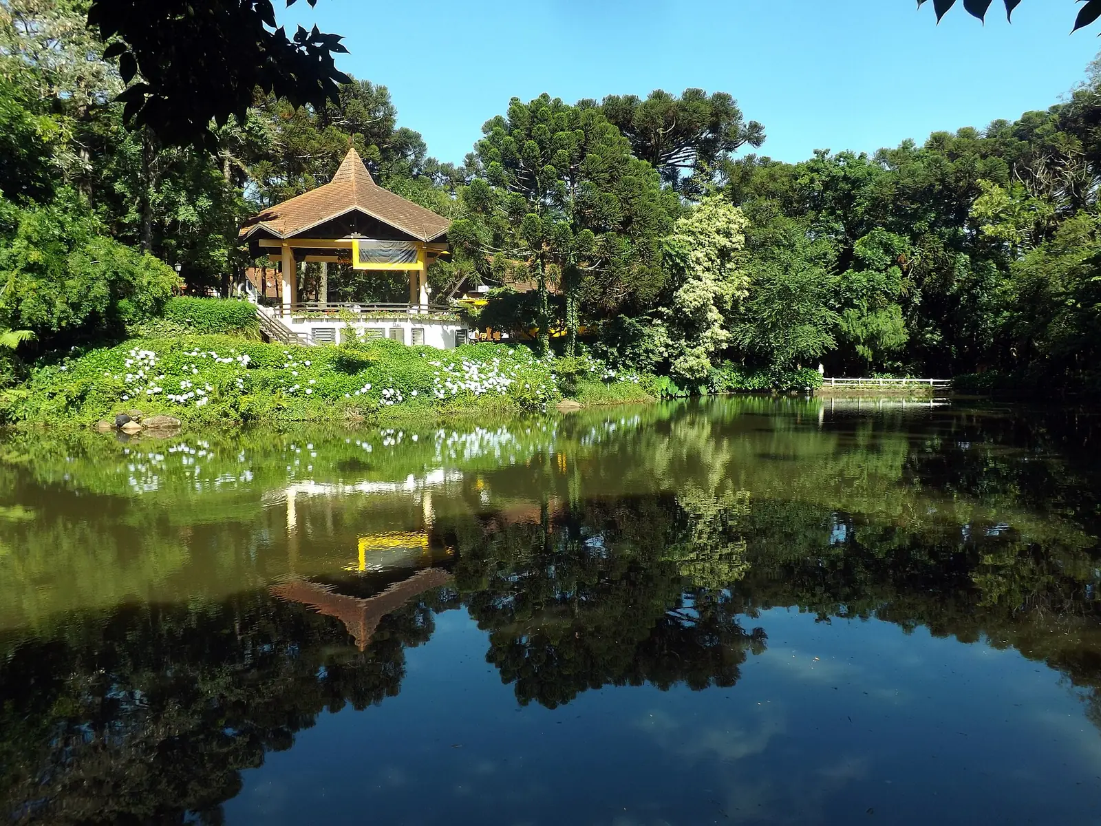 Lago do Parque Aldeia do Imigrante, com um coreto refletido na água